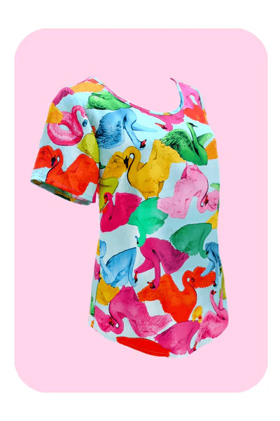 A colorful top displaying an abstract pattern of vibrant swans in reds, greens, and pinks, against a light blue background, with each swan in a unique position, adding movement and whimsy. Designed by Australian designer brand Streborclothing.